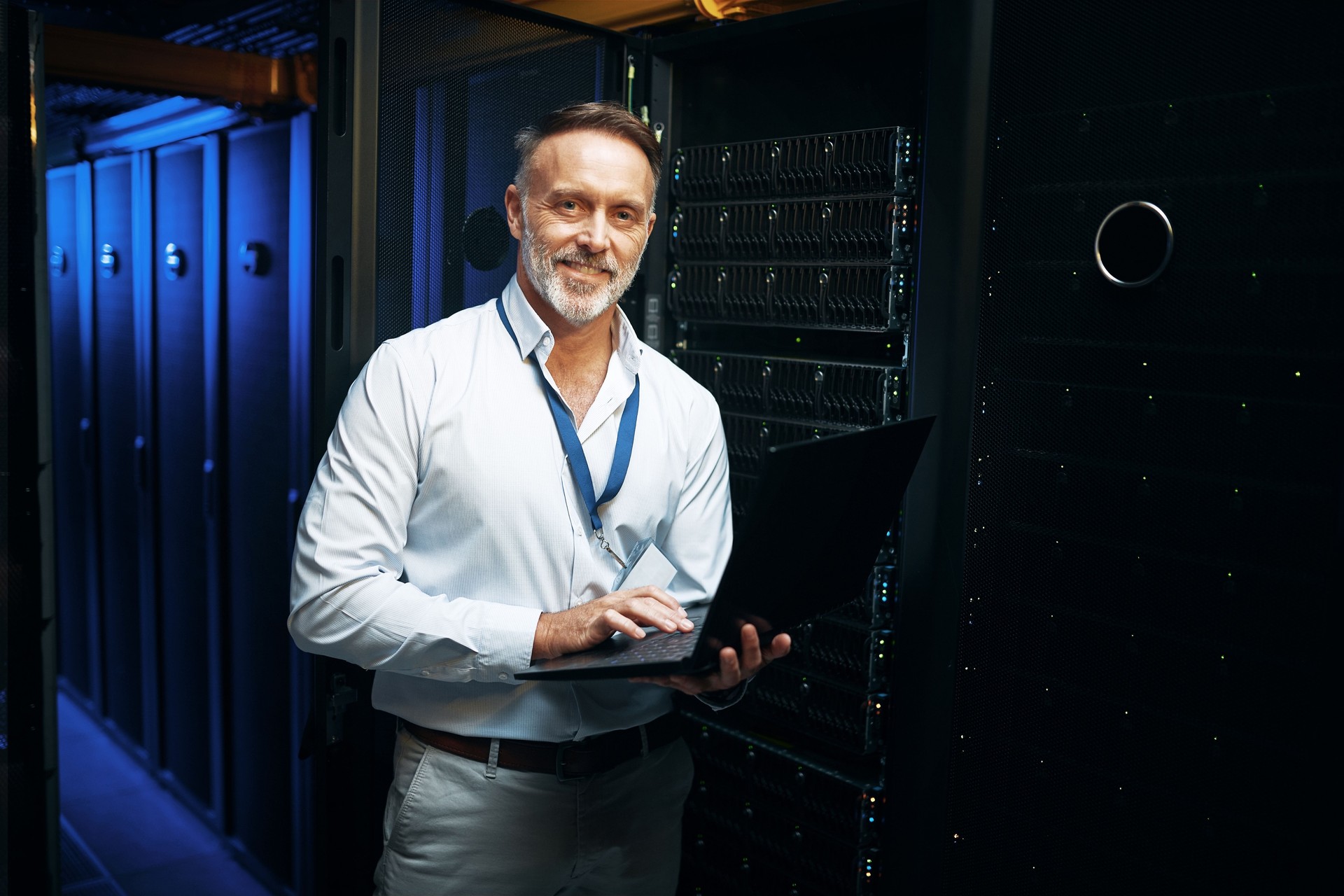 Portrait of a mature man using a laptop while working in a server room