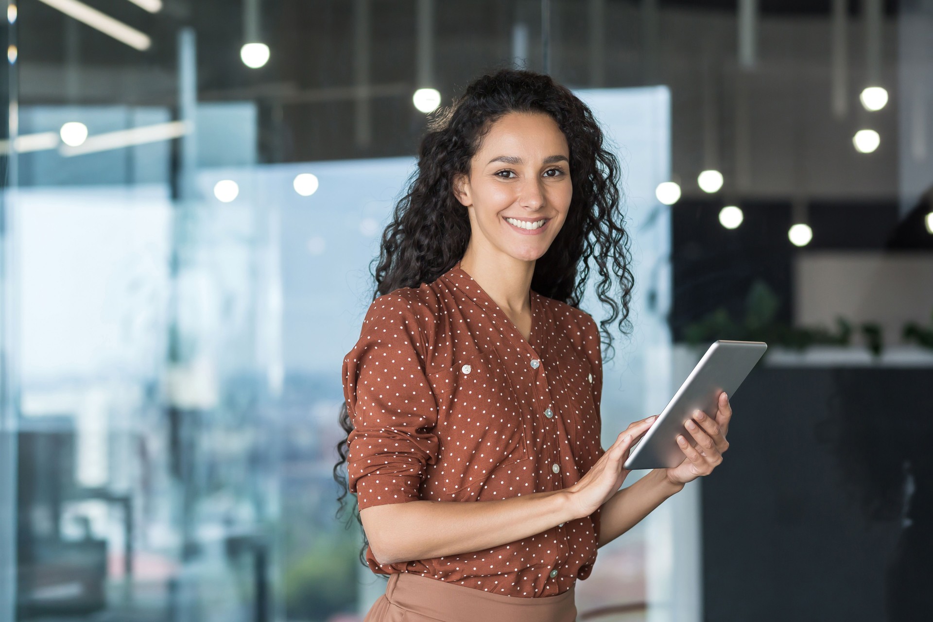 Young and successful female programmer, portrait of female engineer with tablet computer startup worker working inside office building using tablet for testing applications smiling looking at camera