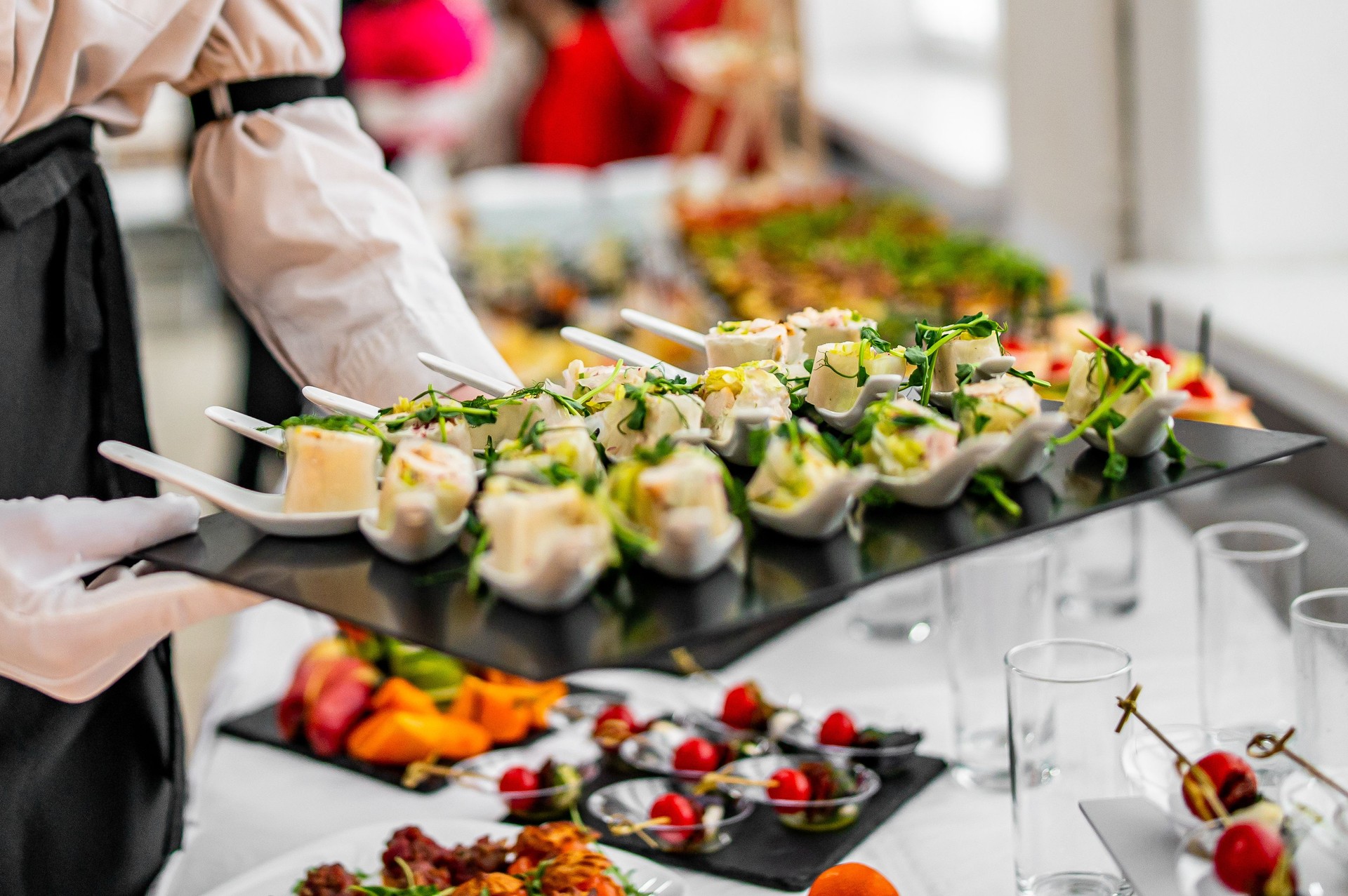 woman hands of a waiter prepare food for a buffet table in a restaurant